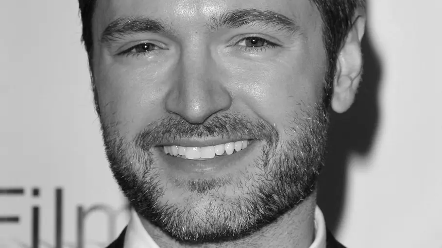 „RuPaul’s Drag Race“-Juror Lucian Piane Todesursache Schwarz-Weiß-Foto zeigt „RuPaul’s Drag Race“-Juror Lucian Piane (46) mit Dreitagebart und einem Lächeln.