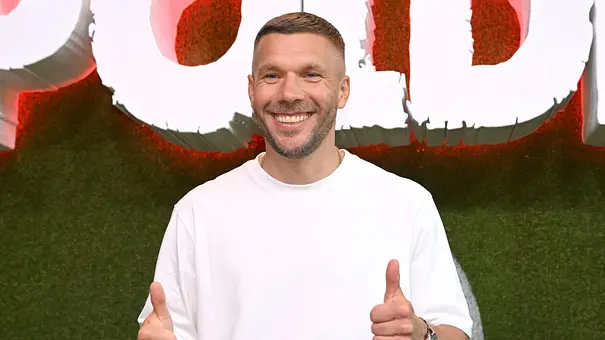 Lukas Podolski schaut lächelnd in die kamera. - Foto: IMAGO / Future Image