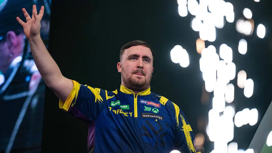 Luke Littler bei der Darts-WM 2026 Luke Littler jubelt mit seiner rechten Hand bei der PDC-WM 2026. Im Hintergrund ist ein kleines Feuerwerk zu sehen!
