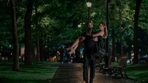 Adam läuft durch einen Park, er hält Olive im Brautstil. - Foto: Prime Video