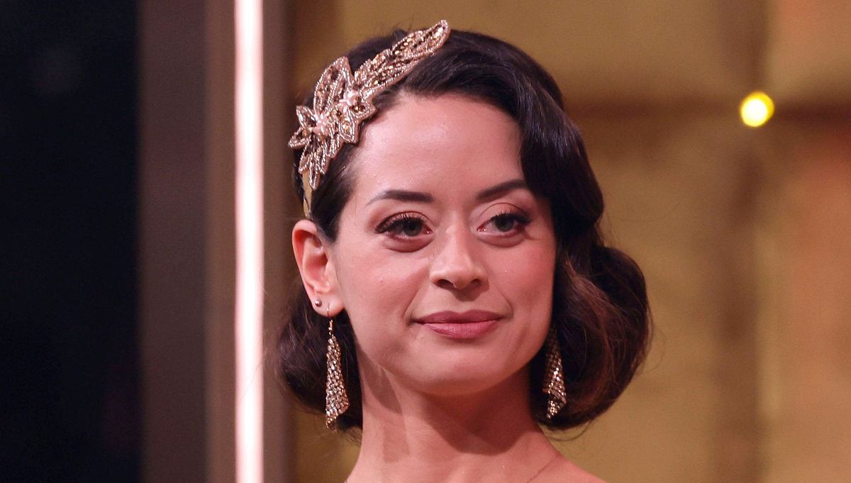 Malika Dzumaev hat sich operieren lassen. Malika Dzumaev mit ernstem Blick, sie trägt auffälligen Kopfschmuck.