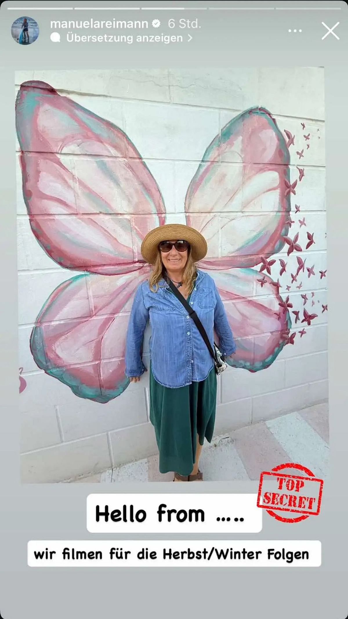 Manu Reimann vor geheimer Kulisse Manuela Reimann posiert vor einer bemalten Wand und wird so zum Schmetterling