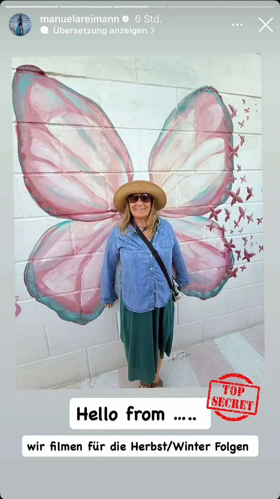 Manu Reimann vor geheimer Kulisse Manuela Reimann posiert vor einer bemalten Wand und wird so zum Schmetterling