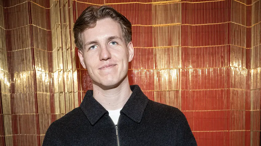Marcant „Creator of the Year“ Auszeichnung. Marcant mit kurzen braunen Haaren und dunkler Jacke steht vor einem rot-goldenen Vorhang und lächelt leicht.