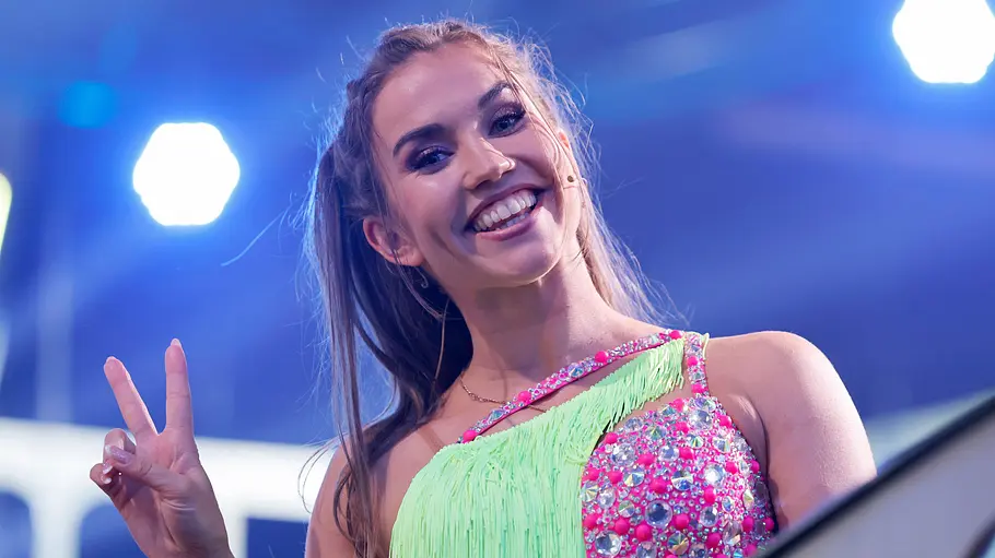 Mariia Maksina gibt einen intimen Einblick von ihrer Hochzeit. Mariia Maksina macht ein Peace-Zeichen und lacht.