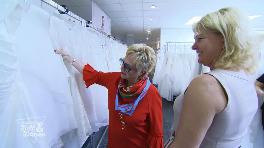 Maritta Emser Maritta Emser berät eine Kundin im Brautmodengeschäft und zeigt auf ein Hochzeitskleid, während die Braut aufmerksam zuhört.