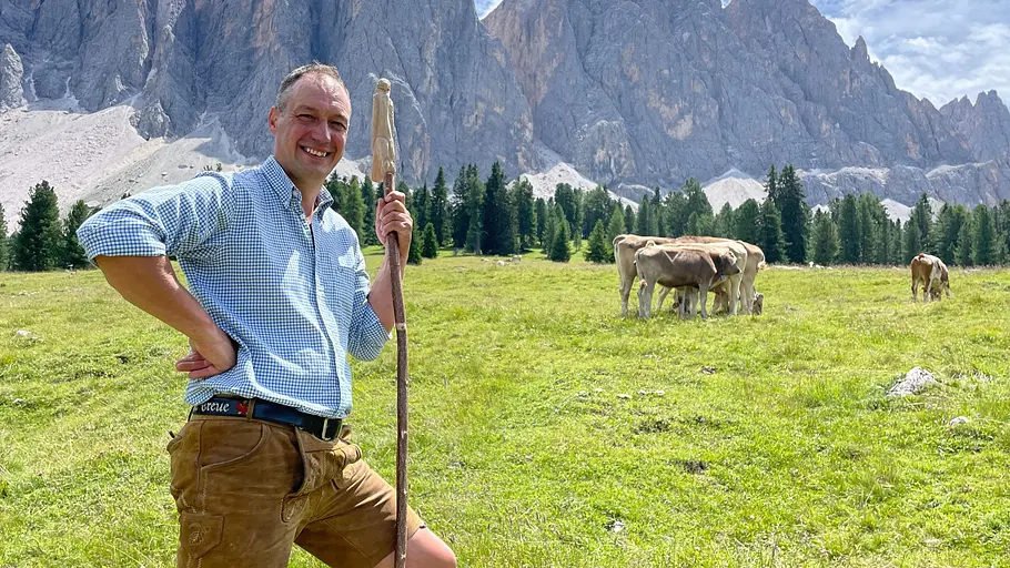 Markus wohnt in Italien. Markus vor Bergkulisse auf der Weide.
