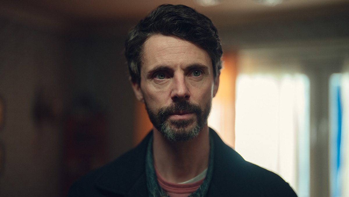 Matthew Goode als DCI Carl Morck in „Dept. Q“. Carl Morck schaut leicht beunruhigt nach links, der Hintergrund ist unscharf.