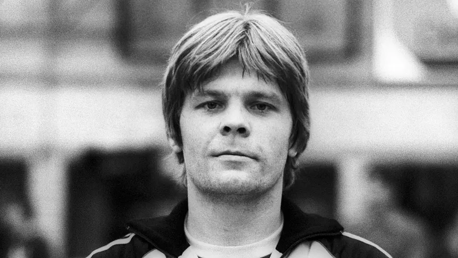 Matthias Strauss ist tot Matthias „Matzi“ Strauss trägt eine Trainingsjacke mit Bundesadler und blickt in die Kamera. Die Aufnahme ist schwarz-weiß.
