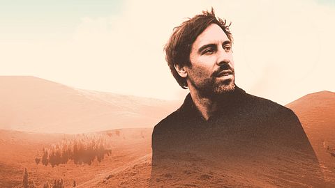 Song Trip: Max Giesinger x Mongolei: Montage: Im Hintergrund liegt eine, in orangefarbene Töne getauchte, karge Landschaft mit Hügeln und einigen Bäumen. Davor liegt eine Porträtaufnahme des Musikers Max Giesinger. Er schaut zur Seite. - Foto: ZDF / Korbinian Maier / [M] Simon Marchner