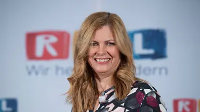 Maxi Biewer posiert für die Kamera vor einem RTL Stand - Foto: IMAGO