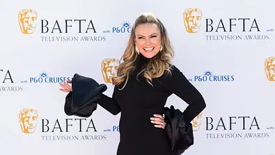 Mel Schilling steht lächelnd vor der Fotowand der BAFTAs.  - Foto: IMAGO / NurPhoto