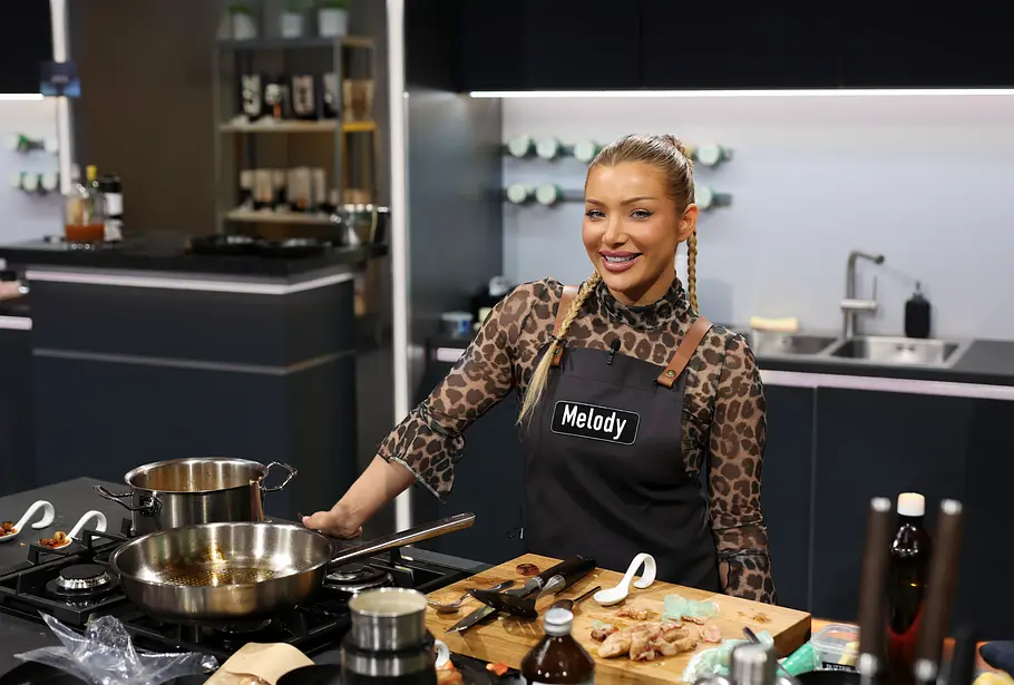 Melody Haase in der „The Taste“ Studioküche am Herd in einem Leoparden-Longsleeve mit schwarzer Schürze