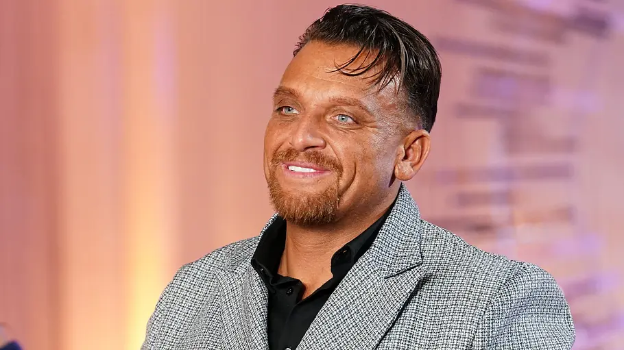 Menowin Fröhlich ist wieder Papa geworden. Menwowin Fröhlich lächelt im grauen Anzug.