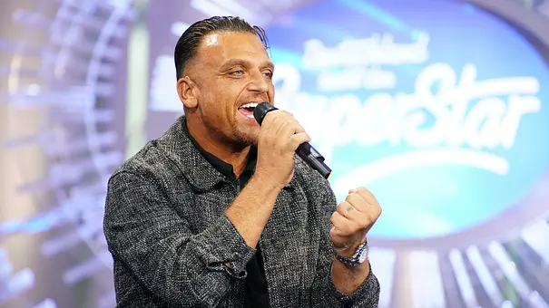 Menowin Fröhlich singt mit ausdrucksstarker Mimik in ein Handmikrofon auf der Bühne von „Deutschland sucht den Superstar“. - Foto: RTL / Stefan Gregorowius