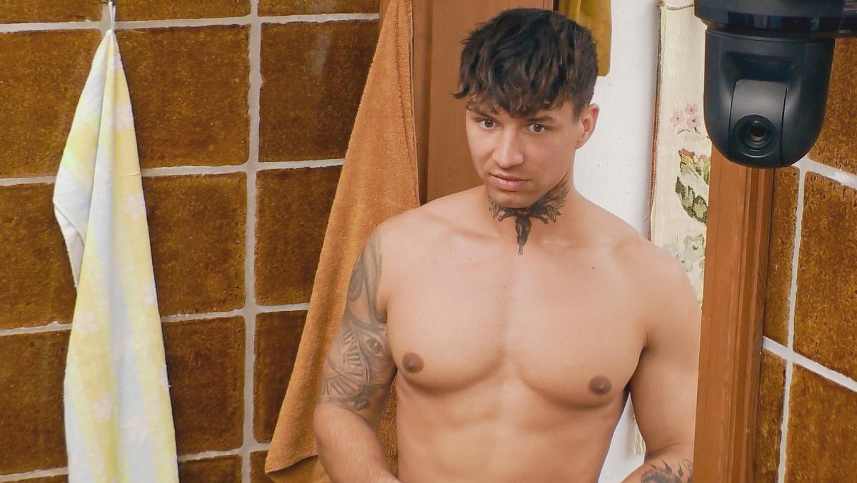 Micha im Sommerhaus der Stars steht oberkörperfrei im Badezimmer. 
