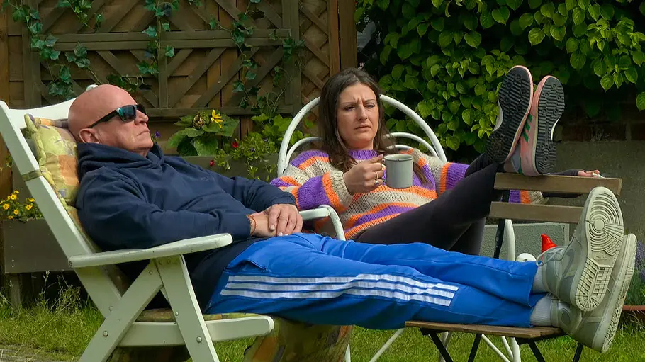 Michael Naseband und Shelly Braun Michael Naseband und Shelly Braun sitzen mit hochgelegten Beinen im Garten. Sie hält einen Becher, er trägt eine Sonnenbrille.