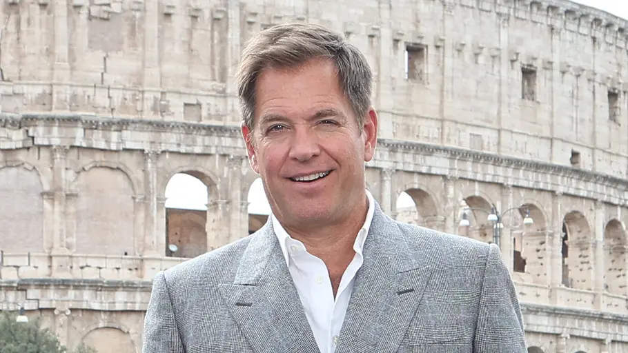 Michael Weatherly kehrt zu NCIS zurück. Michael Weatherly lächelt in die Kamera. Er trägt ein weißes Hemd und einen grauen Blazer.
