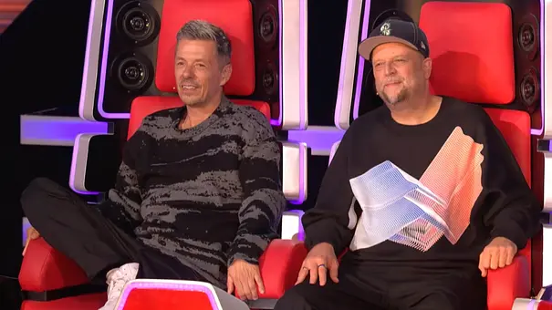 Michi & Smudo sitzen in ihrem Doppelstuhl bei The Voice of Germany und lächeln zufrieden.  - Foto: Seven.One Entertainment Group GmbH