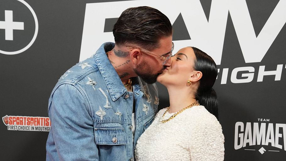 Leyla und Mike Heiter küssen sich vor einer Fotowand