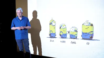 Pierre Coffin steht vor einer Leinwand auf der Zeichnungen von Minions zu sehen sind. - Foto: Pierre Coffin steht vor einer Leinwand auf der Zeichnungen von Minions zu sehen sind. Pierre Coffin steht vor einer Leinwand auf der Zeichnungen von Minions zu sehen sind. - Foto: Pierre Coffin steht vor einer Leinwand auf der Zeichnungen von Minions zu sehen sind.