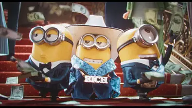 Drei Minions stehen in extravaganten Outfits auf einer Treppe und prassen mit Geld. - Foto: © Universal Studios. All Rights Reserved.
