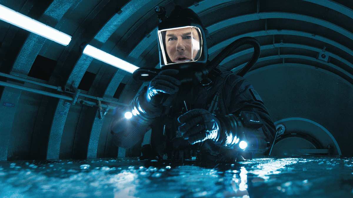Tom Cruise gibt wieder alles, doch das ist diesmal nicht genug. Tom Cruise als Ethan Hunt in einem Taucheranzug. Er befindet sich in einer spärlich beleuchteten Kammer, das Wasser reicht ihm bis zur Hüfte.