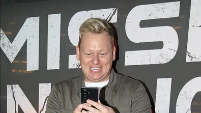 Knossi schaut bei der Premiere von Mission Unknown begeistert aufs Handy. - Foto: IMAGO / Matthias Wehnert