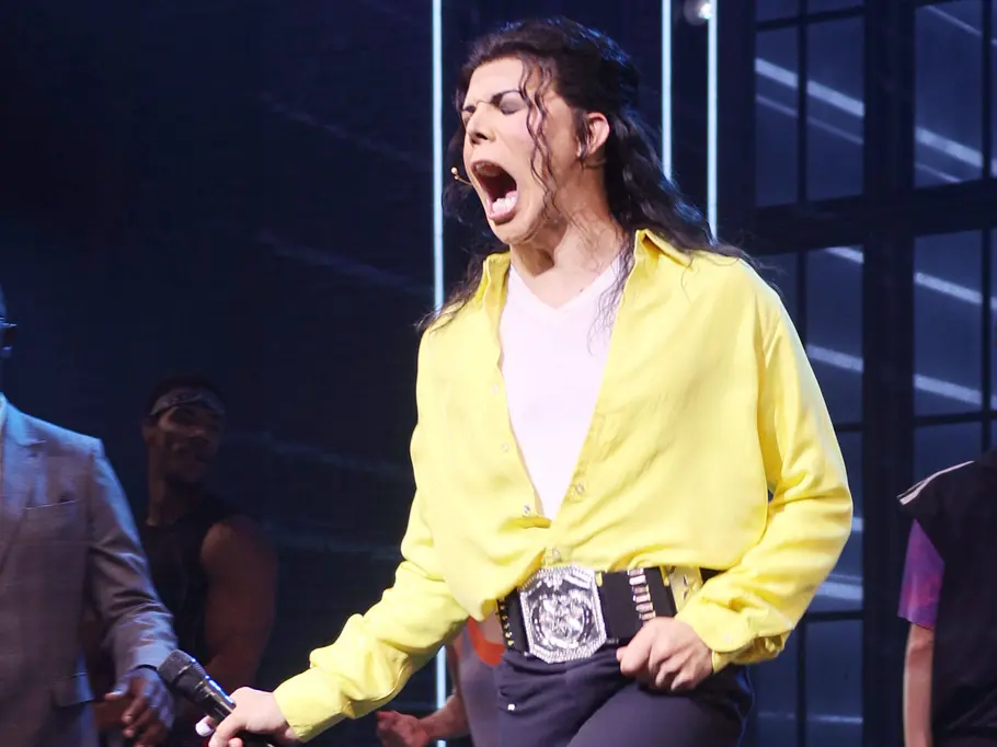 Erik Hamilton als Michael Jackson im Musical „MJ“ mit weit geöffnetem Mund, gelbem Hemd und schwarzer Hose.