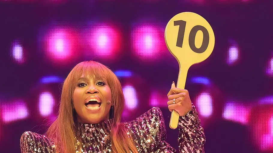 Motsi Mabuse In einem glitzernden Kleid hebt Motsi Mabuse die 10-Punkte-Kelle von „Let’s Dance“ in die Luft und scheint gerade ihre Bewertung anzusagen.