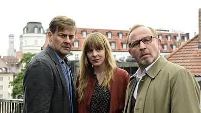 Auf der Straße, nachts, allein: Die drei Kommissare Harald Neuhauser (Marcus Mittermeier), Angelika Flierl (Bernadette Heerwagen) und Ludwig Schaller (Alexander Held) stehen zusammen auf einer Terrasse und blicken an der Kamera vorbei. - Foto: ZDF/Jürgen Olczyk, Honorarfrei