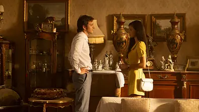 Kemal und Füsun stehen einander in einem Wohnzimmer gegenüber.  - Foto: Courtesy of Netflix