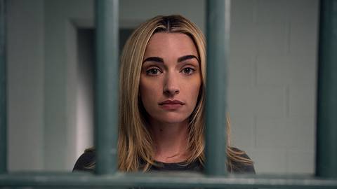 Georgia blickt emotionslos durch Gitterstäbe direkt in die Kamera.  - Foto: Netflix