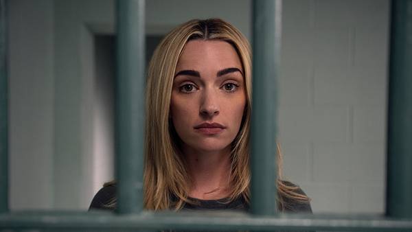 Georgia blickt emotionslos durch Gitterstäbe direkt in die Kamera.  - Foto: Netflix