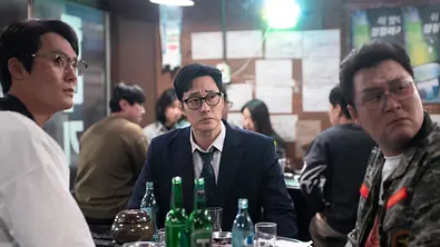 Do-hyeon sitzt mit seinen Freunden in einer Bar und trinkt Soju. Die drei schauen verwirrt zur Seite. - Foto: Netflix