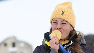 Skicrosserin Daniela Maier mit gelber Mütze küsst ihre Goldmedaille bei Olympia 2026. - Foto: IMAGO / ABACAPRESS