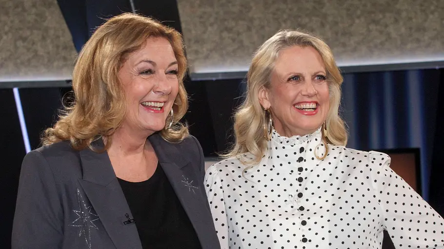 Bettina und Barbara Bettina und Barbara stehen nebeneinander, eine im grauen Blazer, die andere in einer weißen Bluse mit schwarzen Punkten.