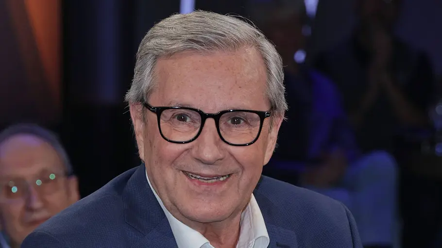 Jan Hofer sitzt im NDR-Studio auf einem Sessel, trägt einen blauen Anzug und lächelt in die Kamera.