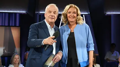 Bettina Tietjen und Hubertus Meyer-Burckhardt stehen im Studio der „NDR Talk Show“ mit Mikrofonen vor Publikum - Foto: IMAGO / Stephan Wallocha