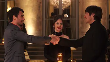 Emily steht zwischen Marcello und Gabriel, die sich die Hand reichen - Foto: COURTESY OF NETFLIX