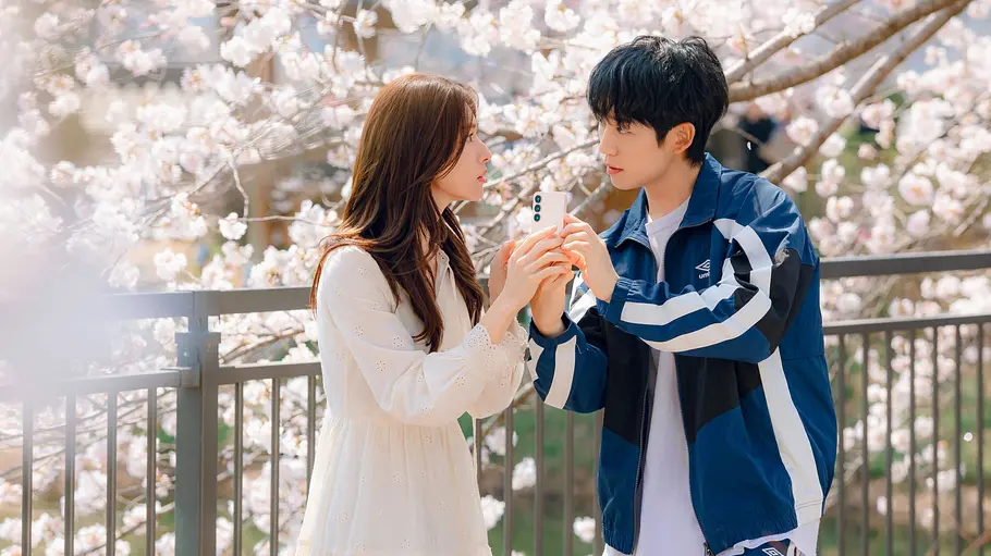 „Our Sticky Love“ Eun-sae und Jang Tae-ha greifen beide nach einem Handy und schauen sich an.