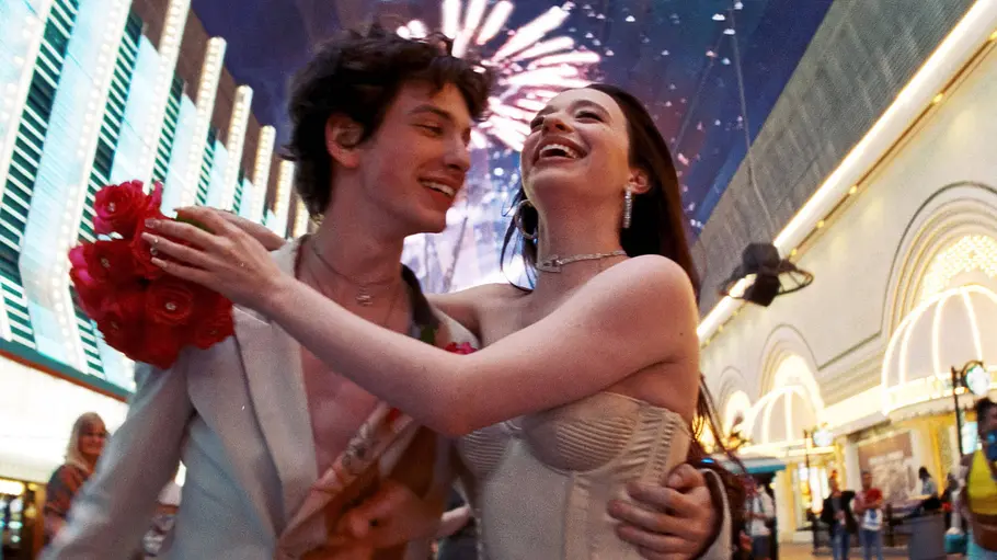 Anora und Ivan turteln nach ihrer Hochzeit in Vegas. Sie hält ein Bouquet aus roten Blumen.