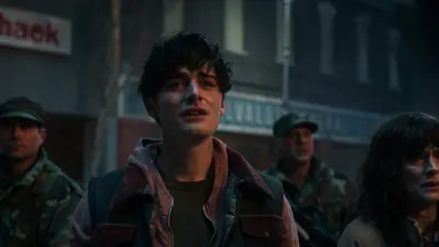 Will und seine Mutter Joyce schauen in die Ferne und haben Tränen in den Augen. Sie sind von Soldaten umgeben. - Foto: COURTESY OF NETFLIX © 2025