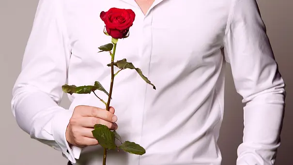 Ein Mann im weißen Hemd hält eine rote Rose in der Hand.  - Foto: RTL