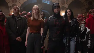 Karen Page, Daredevil und Jessica Jones schauen mit anderen Menschen im Hintergrund nach oben. - Foto: TMDB
