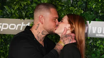 Nico Legat und Freundin Laura küssen sich bei einem Pressetermin mit geschlossenen Augen. - Foto: IMAGO / BOBO Nico Legat und Freundin Laura küssen sich bei einem Pressetermin mit geschlossenen Augen. - Foto: IMAGO / BOBO