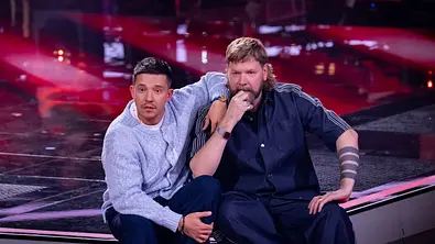 Nico Santos und Rea Garvey sitzen auf der Bühne von The Voice of Germany und schauen erstaunt zu den Juroren - Foto: Joyn