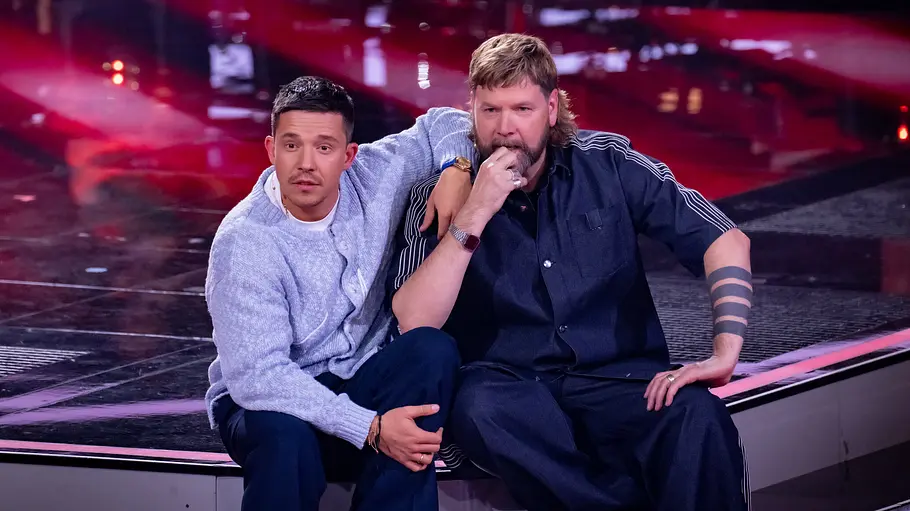 The Voice of Germany Nico und Rea Nico Santos und Rea Garvey sitzen auf der Bühne von The Voice of Germany und schauen erstaunt zu den Juroren