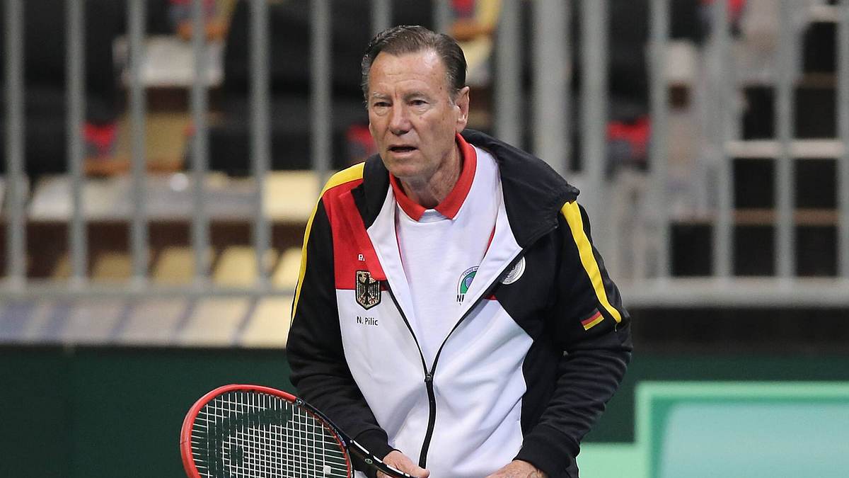 Niki Pilić hält mit ernster Miene einen Tennisschläger in der Hand und wirkt konzentriert.