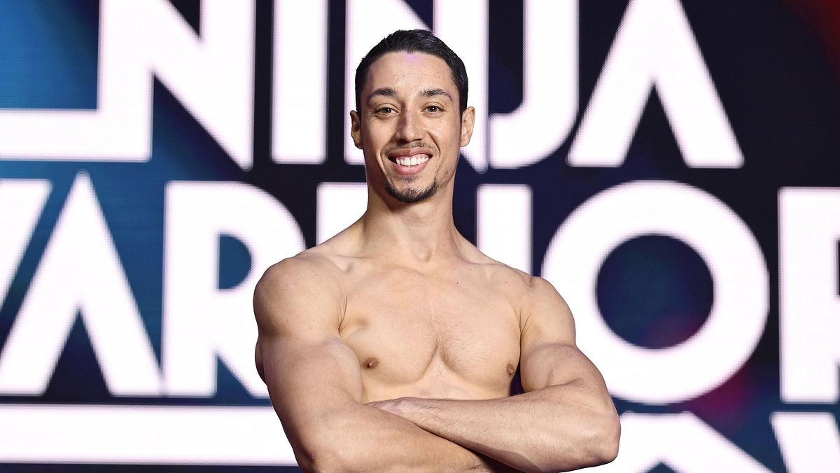 Ninja Warrior Germany Gewinner René Casselly René Casselly vor dem Ninja Warrior Germany-Logo
